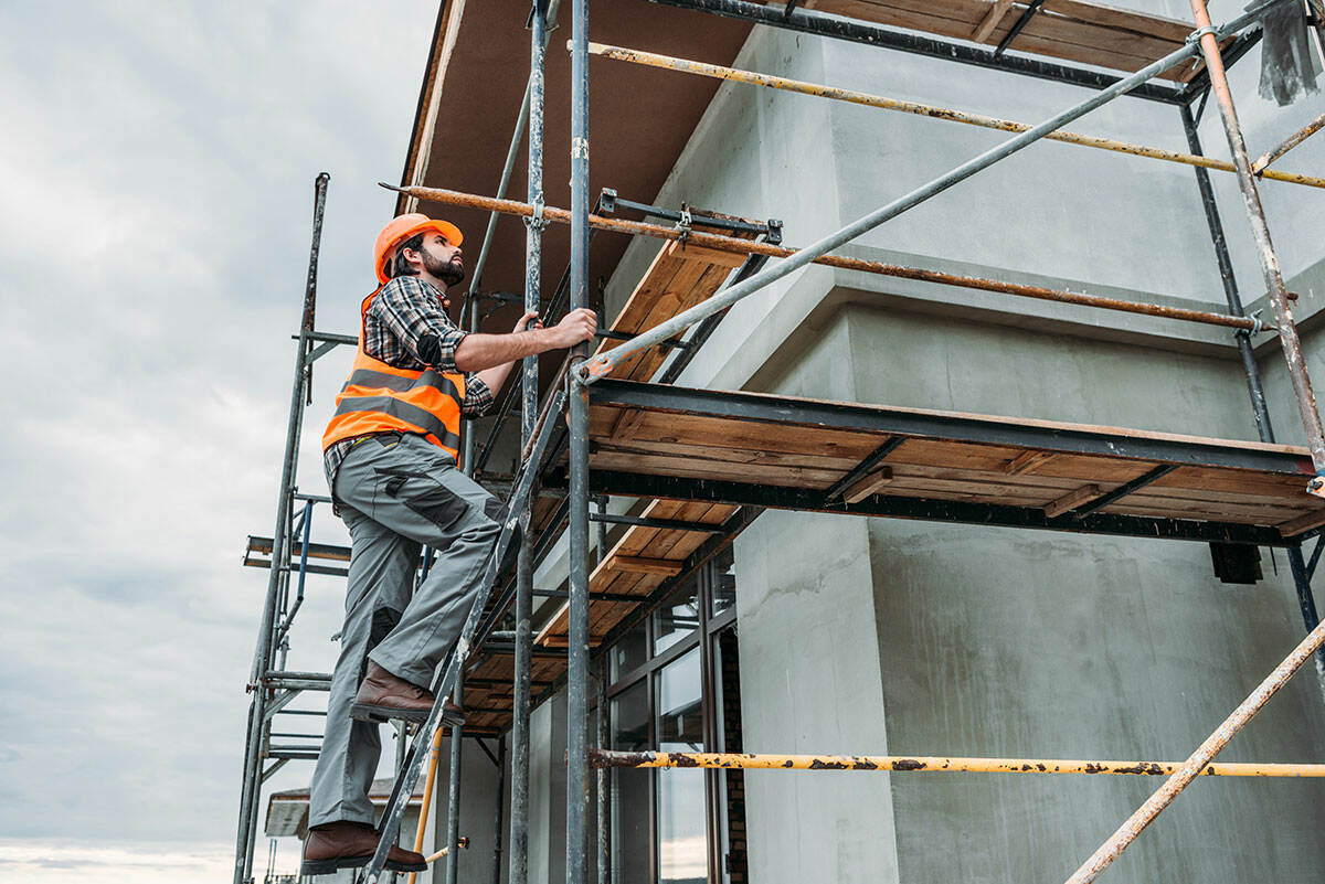 handsome-builder-climbing-on-scaffolding-at-constr-KDPFESA-baitasite